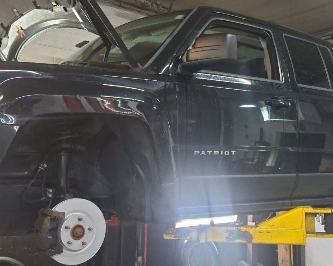 Black Jeep Patriot undergoing brake repair at Allen's QAC.