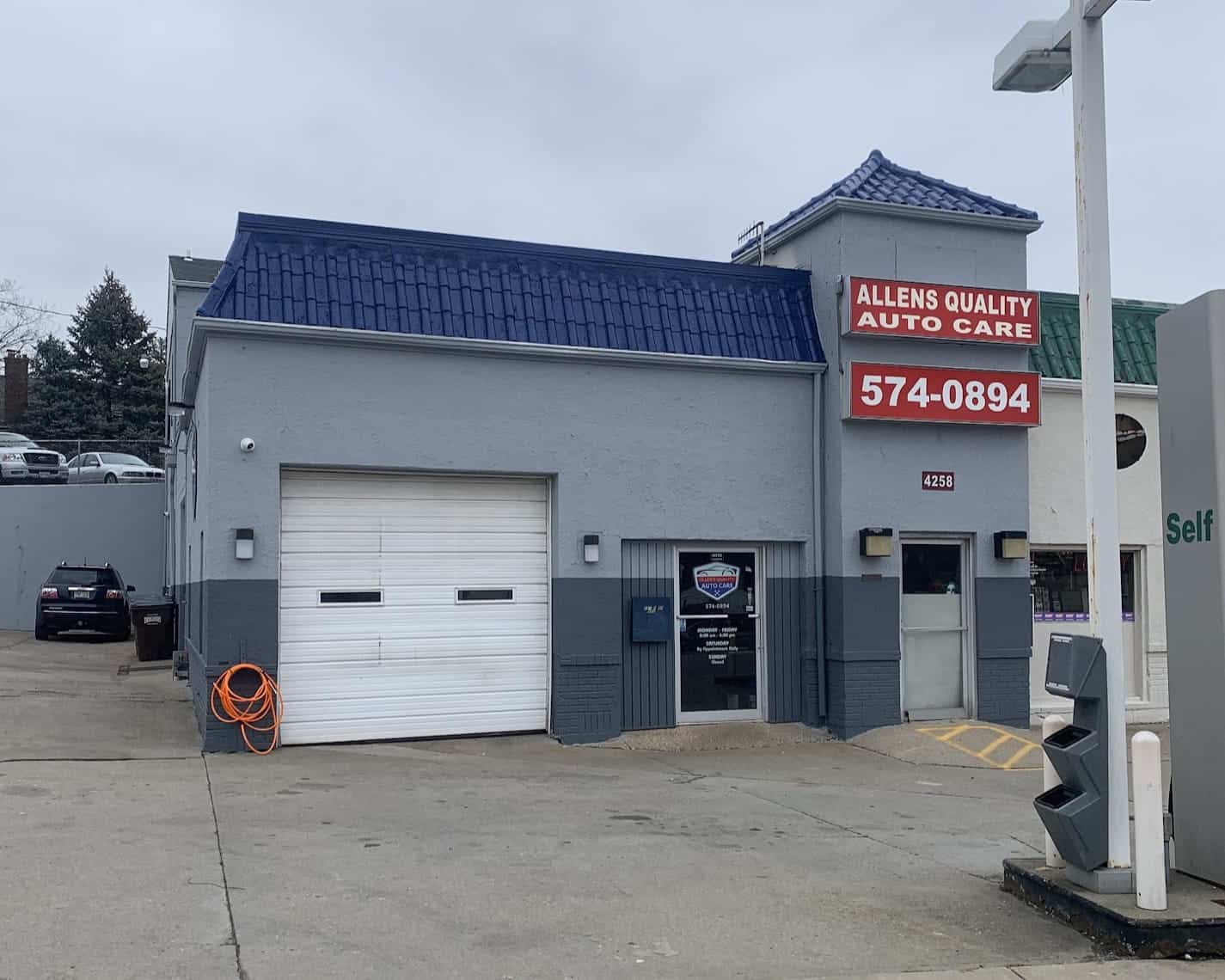 Auto repair shop with blue roof and signage for Allen's Quality Auto Care.