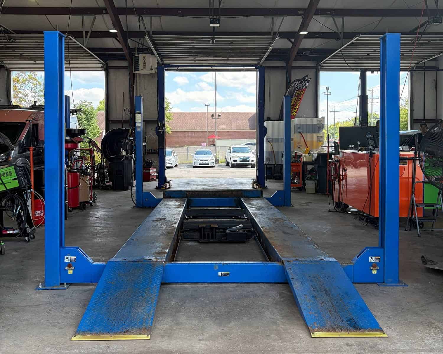 Automotive lift inside a busy auto repair shop at Allen's Quality Auto Care.