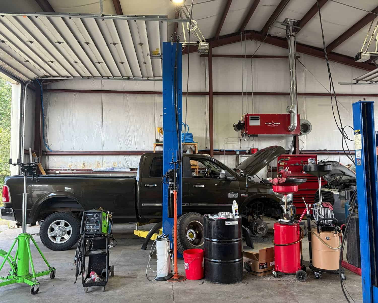 Auto repair shop with a black pickup truck on a lift at Allen's Quality Auto Care.