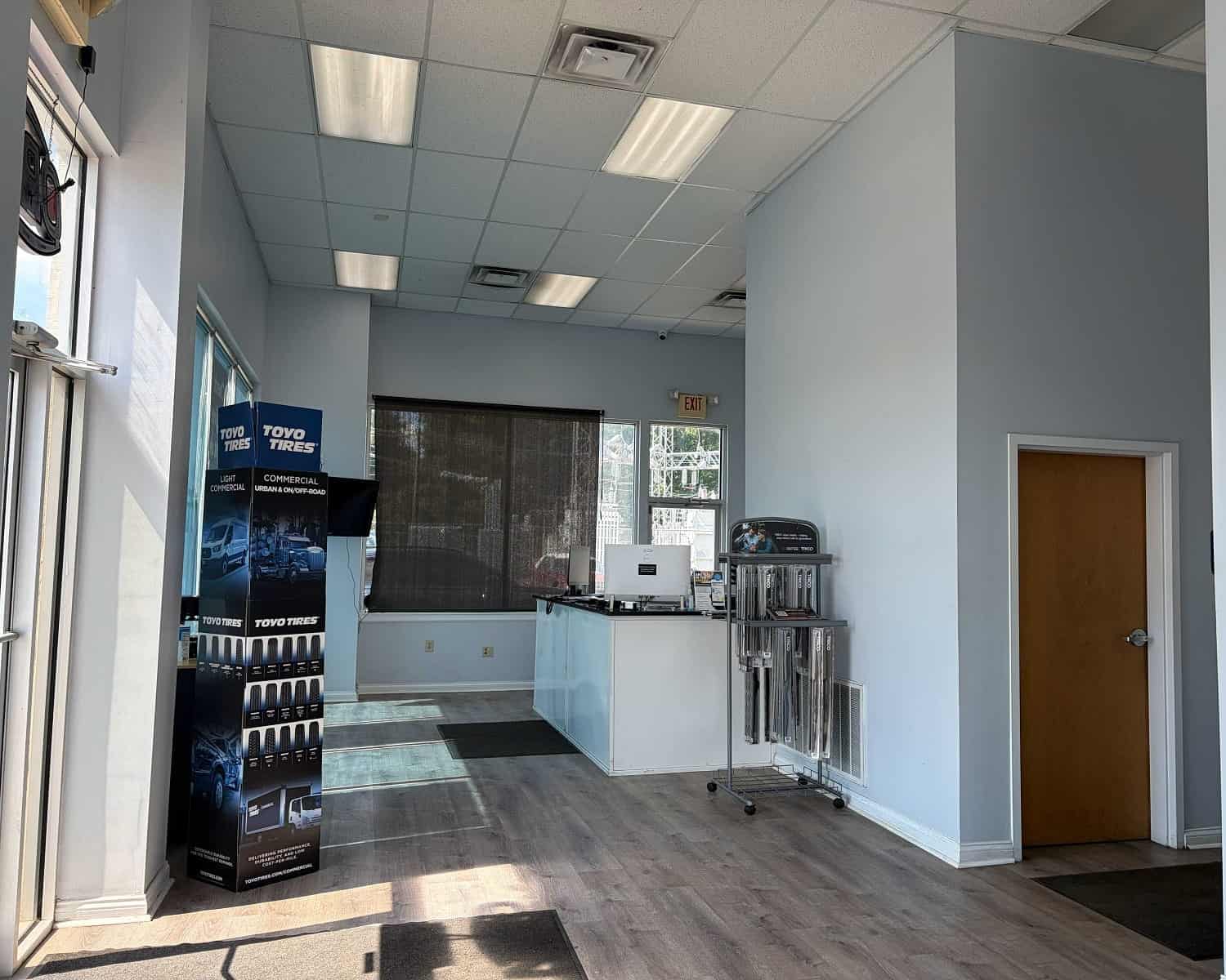 Clean auto repair shop interior with service desk and tire display.