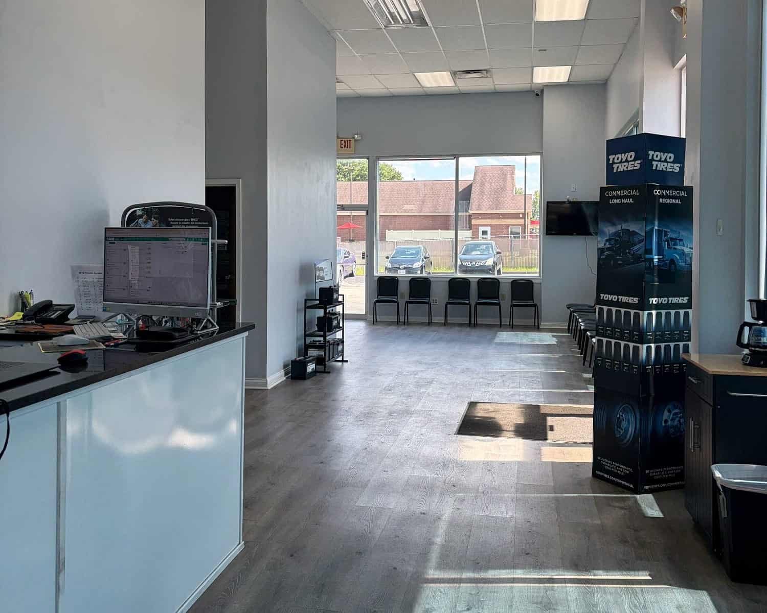 Clean auto repair shop with customer seating and tire display area.