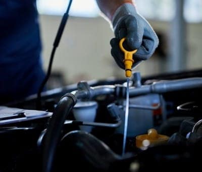Technician inspecting car engine with diagnostic tools at Allen's Auto Care.