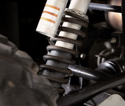 Close-up of a car suspension system during auto repair at Allen's Quality Auto Care.
