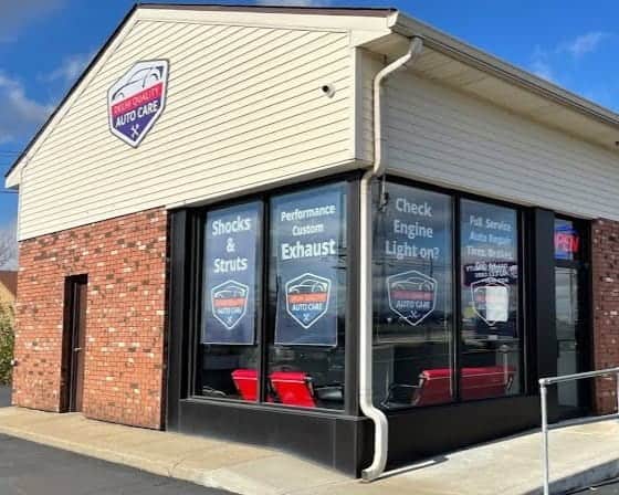 Auto repair shop with signs for shocks, exhaust, and engine check services.