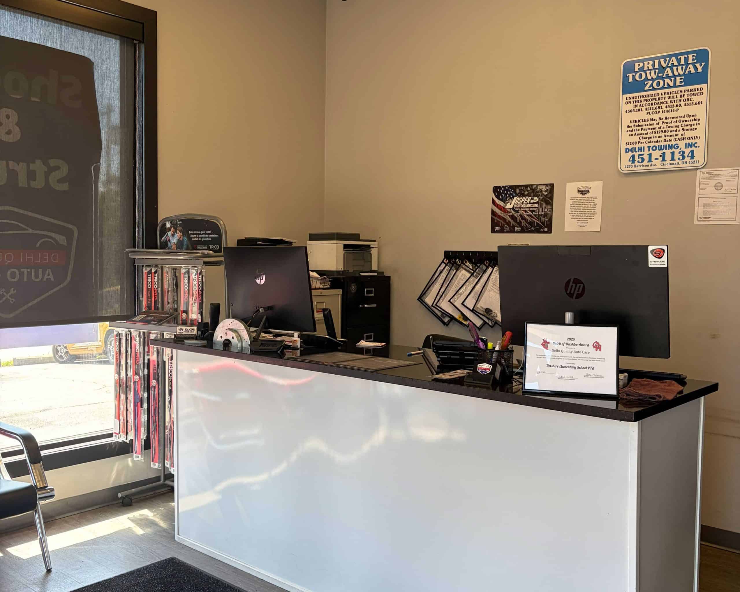 Auto repair office desk with computers and office supplies.