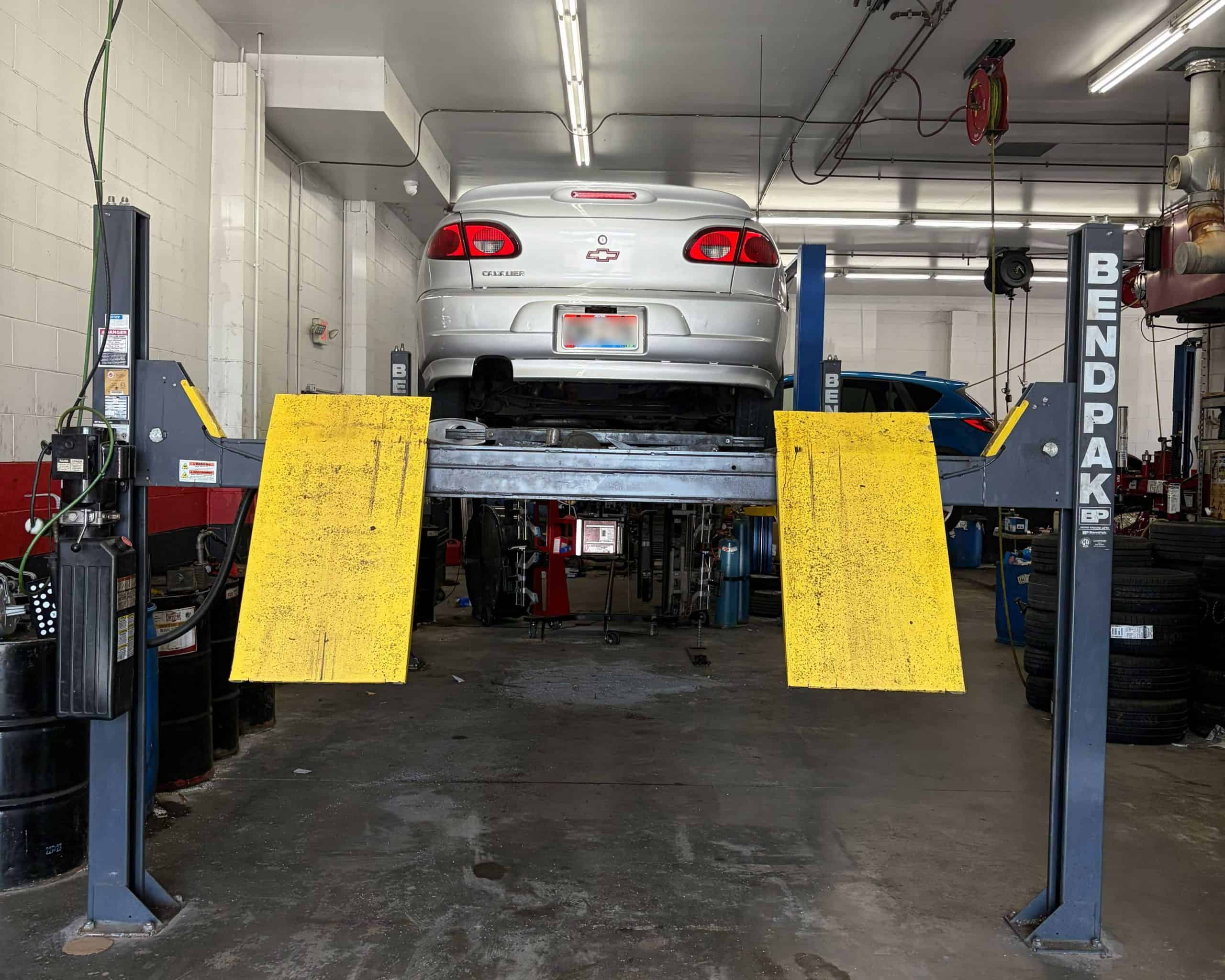 Car on hydraulic lift at Allen's Quality Auto Care in Delhi QAC.